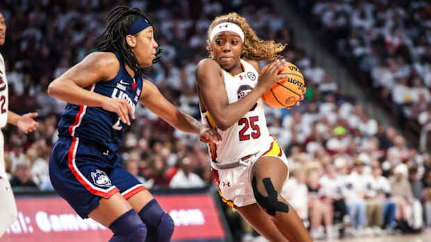 Feb 11, 2024; Columbia, South Carolina, USA; South Carolina Gamecocks guard Raven Johnson (25) drives around UConn Huskies guard KK Arnold (2) in the first half at Colonial Life Arena. 